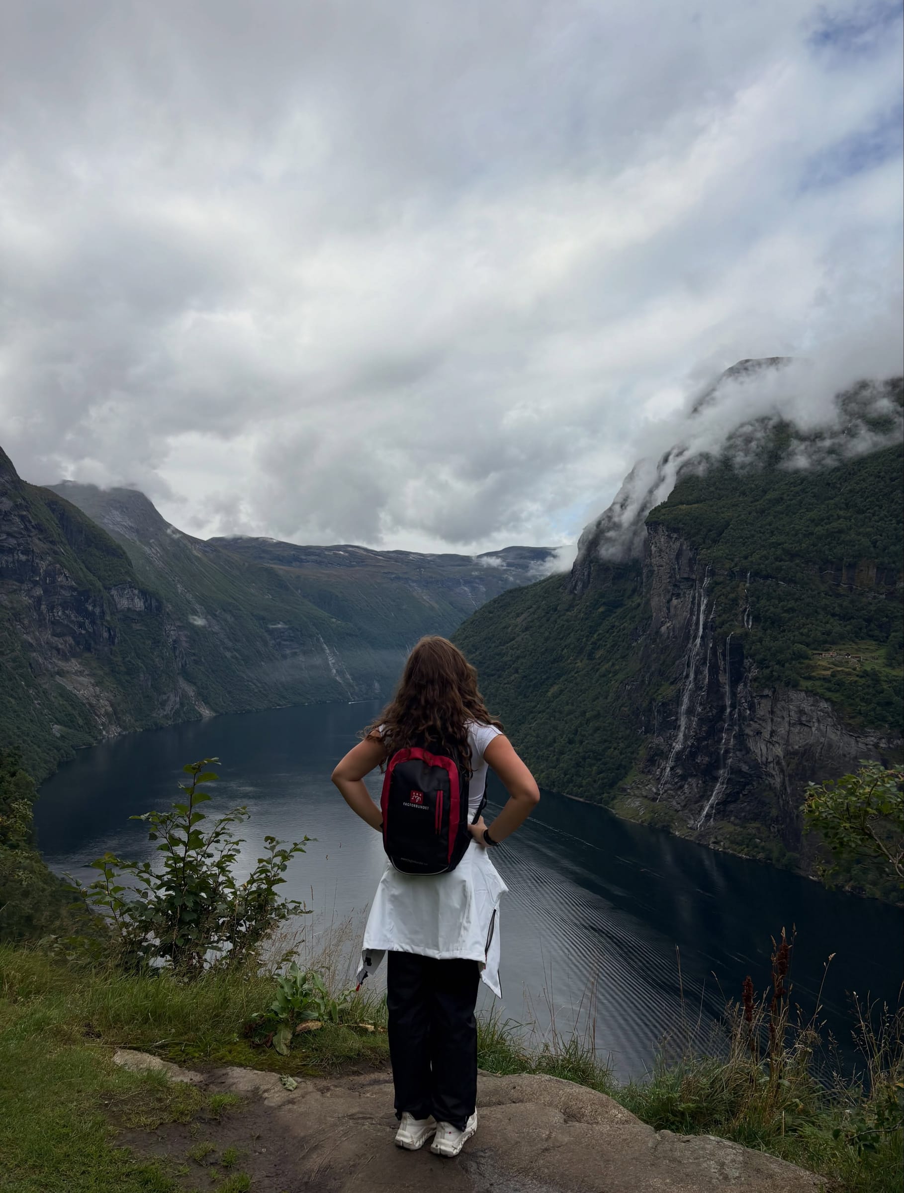 Isla looking out over the Geiranger fjord from the top of the hike